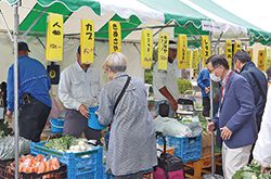 野菜の出店に集まる人々